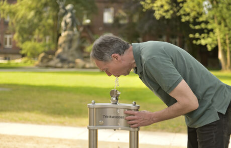 Himberg Trinkwasserbrunnen La Playa, Trinken aus dem Mundspüler Himberg Trinkwasserbrunnen La Playa, Trinken aus dem Mundspüler